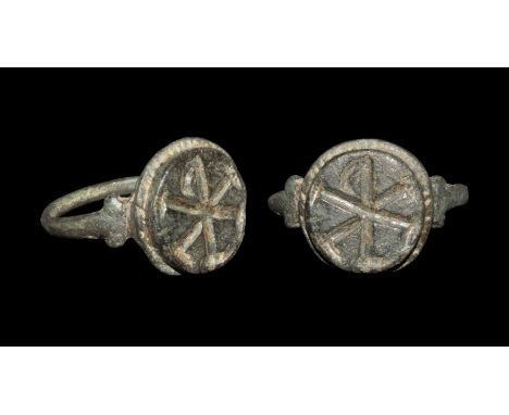 Late 3rd-4th century AD.A narrow round-section bronze hoop with lateral lobes to the shoulders, discoid plaque with pelletted