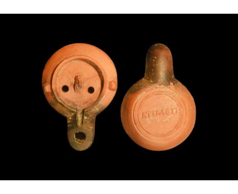 1st century AD.A ceramic factory oil lamp with curved shoulder with two shoulder lugs, bearded actor's mask to the centre of 