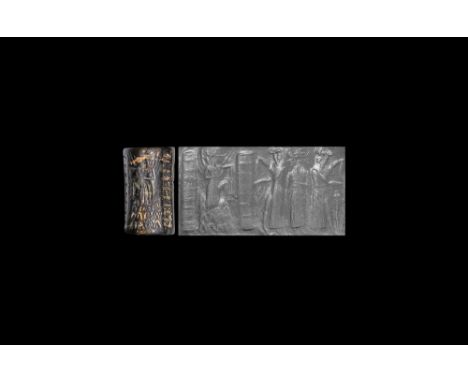Akkadian, late 3rd millennium BC.A large black limestone cylinder seal with two scenes; one with a male deity with weapons to