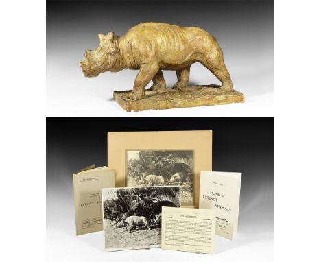 Circa 1930. A master model in surface-treated plaster of a Uintatherium advancing on a textured rectangular base; monochrome 
