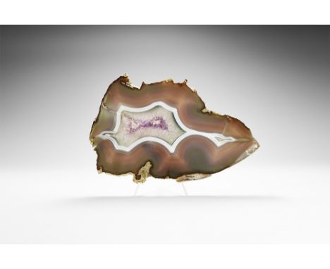 A finely cut slice of purple, green and white banded agate; with lilac and white amethyst crystals to the centre. 528 grams, 