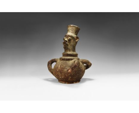 19th-early 20th century AD.A black ceramic jar with bulbous body, basal ring, tubular head with applied eyes and facial featu
