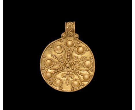 9th-11th century AD.   A discoid gold pendant with raised border, nine prominent discs surrounded by applied wires forming se