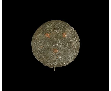 9th-8th century BC.   A sheet bronze discoid brooch with pelletted border, five domed bosses joined by pointillé curled lines