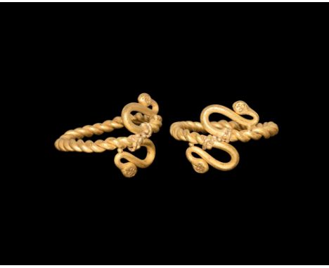 5th-4th century BC. A round-section gold hoop of twisted rods with S-shaped terminals formed as snake-heads, granule detailin