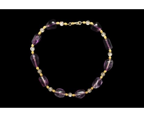 1st millennium BC.A restrung necklace formed from irregular polished amethyst, with later gold and clear spherical quartz bea