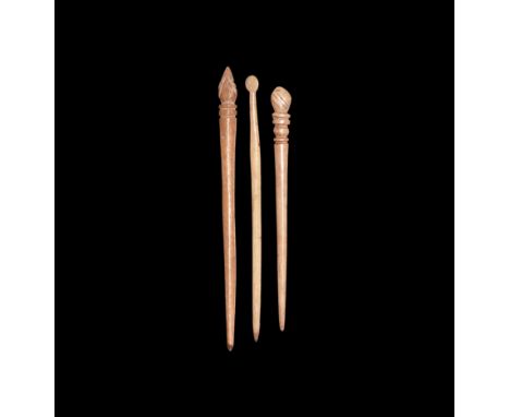 1st-2nd century AD.   A group of three bone pins, each with tapering shank, one with disc head, two with ribbed collar and fl