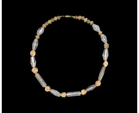 5th-3rd century AD. A restrung necklace of facetted biconical and tubular rock crystal beads with hollow-formed gold spherica