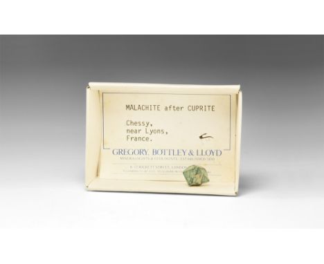 A pseudomorph of malachite replacing a complex octahedral crystal of cuprite from the classic French locality; in white card 