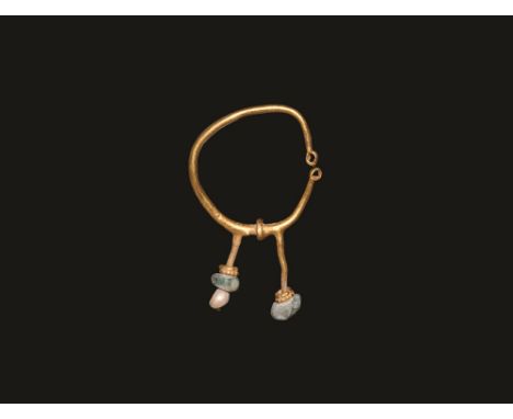 1st-3rd century AD. A gold earring comprising a round-section penannular hoop with loop terminals, flared fillet flanked by t