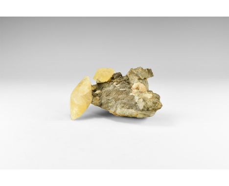 A museum-quality display specimen of calcite on matrix, comprising two large, double-terminated yellow calcite scalenohedra o