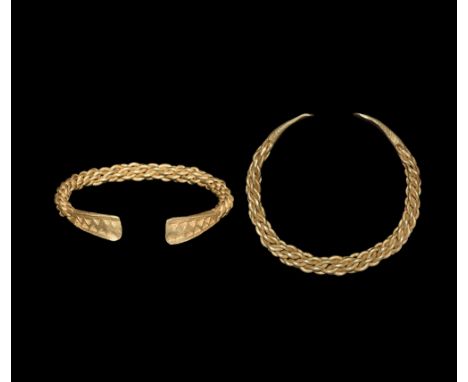 9th-11th century AD.   A large heavy gold bracelet formed as a penannular shank of plaited rods, splayed terminals with punch