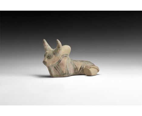 2nd millennium BC.A ceramic figure of a reclining bull, large horns to top of head, hump to the back, one leg to the back; fa