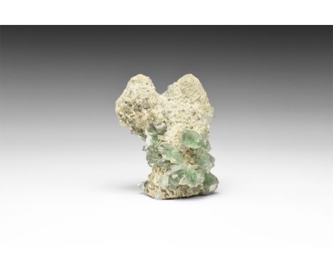 A specimen comprising an unusual stalactitic growth of calcite overgrown with cubes of lavender fluorite; in white card tray 