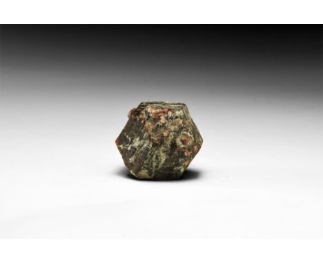A sharply formed dodecahedral garnet crystal, probably almandine, retaining traces of its original schist matrix; in old whit
