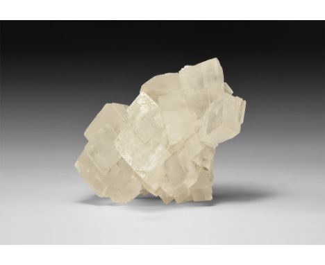A cluster of finely formed rhombohedral calcite crystals showing excellent crystallisation; in white card tray. See Bonewitz,