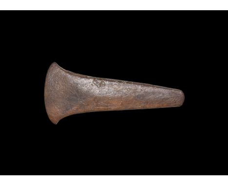 Early 2nd millennium BC.   A copper flat axe blade with tapering shank, slightly curved butt, curved edge with lateral wings.