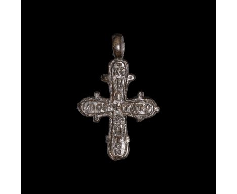 6th-8th century AD.A cruciform bronze pendant with pierced lug above, lateral spurs to each arm, enigmatic inscription 'KEBOH