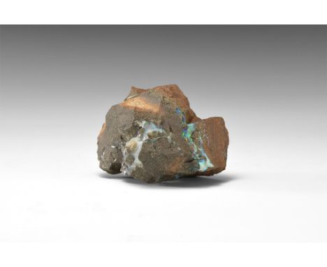 A specimen of gem opal consisting of several seams within a matrix of sandstone and exhibiting blue and green fire; in old wh