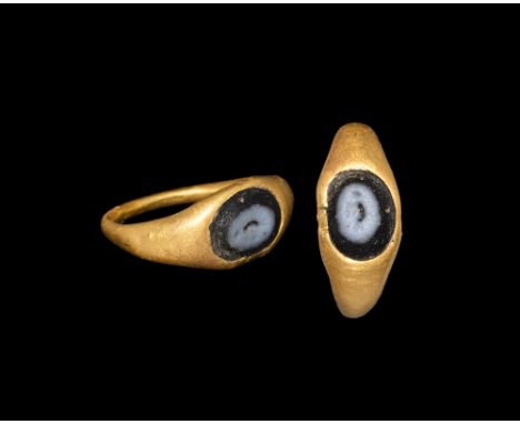 1st-2nd century AD.   A gold ring with D-section hoop widening at the shoulder; bezel set with a blue and black glass intagli