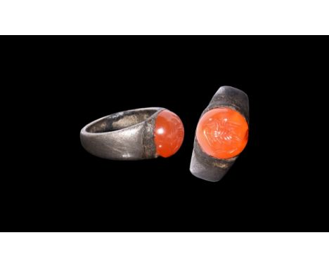 3rd-7th century AD.A flat-section silver hoop with flared shoulders, inset carnelian cabochon with intaglio bird with spread 