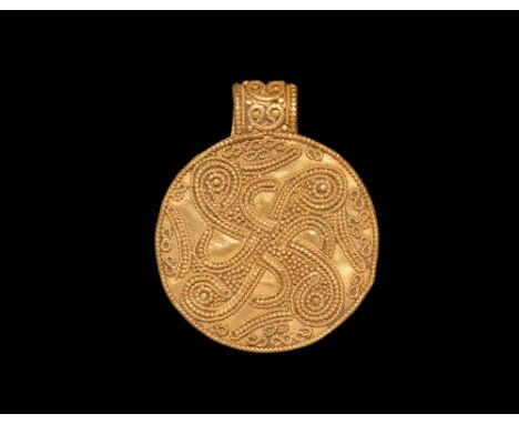 9th-11th century AD.   A gold oval pendant with beaded rim, to the centre a filigree interlaced swastika with the ends of eac