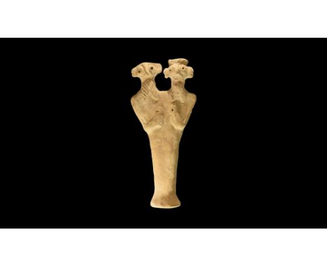 12th-6th century BC.A flat-backed ceramic figurine with two heads; the eyes and breasts formed as appliqué panels with centra