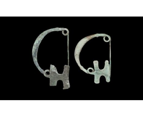 Thracian, 7th century BC.   A pair of bronze brooches with arching bodies widening to the centre, ribbed collar to either end