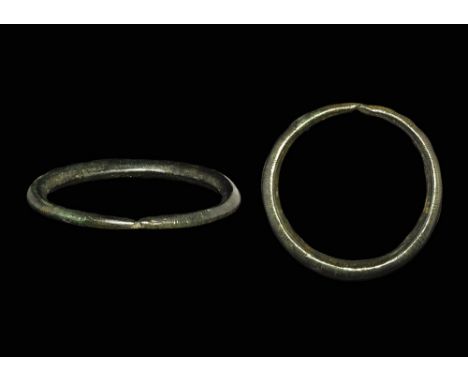 800-500 BC.An ovoid-section penannular bronze bracelet with butted ends, bands of vertical ribbed hatching to the outer faces