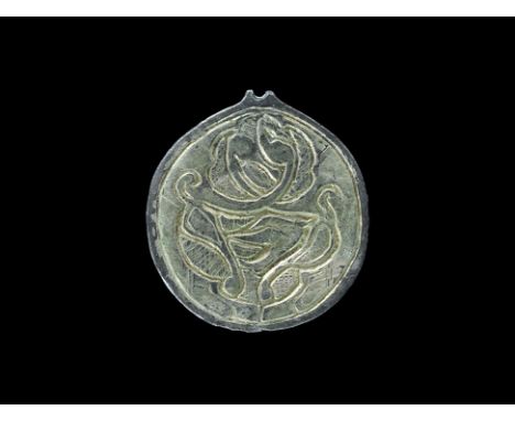 8th-9th century AD.A flat-section disc featuring a silver-gilt central panel displaying a pair of opposed beasts with muzzles
