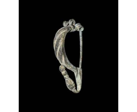 6th-3rd century AD.   A bronze bow brooch with coiled spring, D-section bow with slashed detailing, curved foot with bulb and