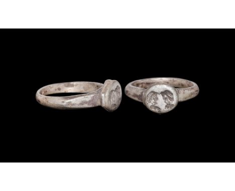 4th-5th century AD.A D-section silver hoop with flat angled shoulders, discoid drum bezel with intaglio of two profile busts.