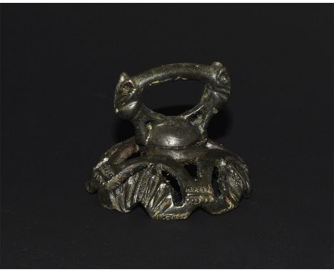 12th century AD.   A finial formed as a strap-end with openwork cap; the strap-end with transverse bar between addorsed beast