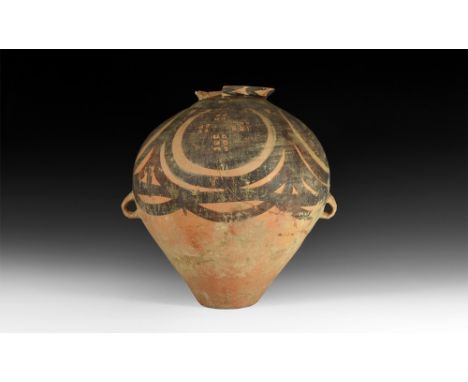 3rd millennium BC.A bulbous ceramic jar with two small loop handles, narrow base and everted rim; decorated to the upper surf