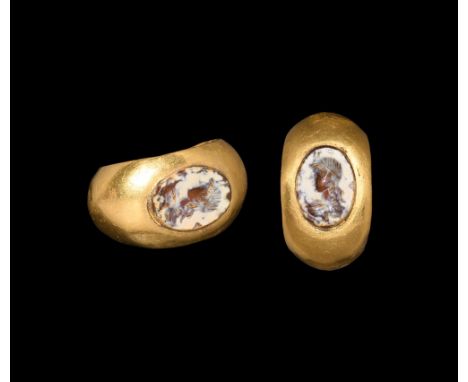 1st-2nd century AD.   A D-section hollow gold hoop with flared shoulders, inset elliptical carnelian intaglio of a profile fe