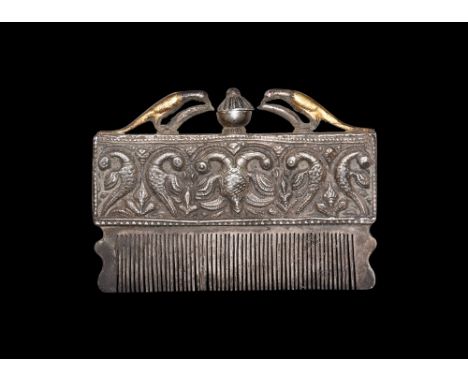 18th-19th century AD.A silver-coloured metal comb, triangular in section with fine-cut teeth and scrolled ends; the handle a 