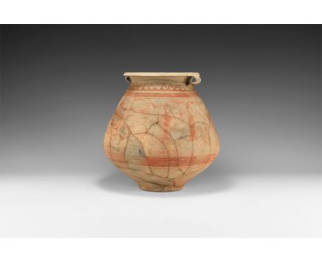 3rd century BC-1st century AD.   A bulbous terracotta jar with dimple base, biconvex body, flared chamfered rim with two late
