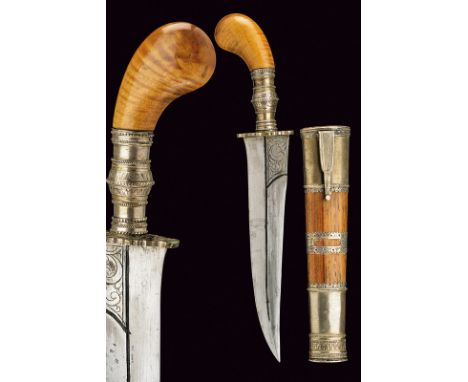 A dagger dating: 20th Century provenance: Indonesia Double-edged blade, engraved at the base; wooden grip with silver ring-nu