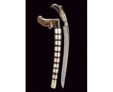 A bade-bade dating: 19th Century provenance: Malaysia Curved, single-edged blade made of pamor; sculpted, horn grip featuring