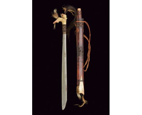 A mandau dating: 19th Century provenance: Borneo Straight, single-edged blade; bone grip, richly carved and featuring black a