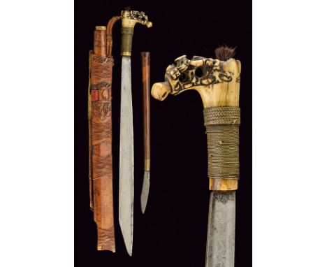 A mandau dating: late 19th Century provenance: Borneo Straight, single-edged blade,. Typical, bone grip, richly carved and pi