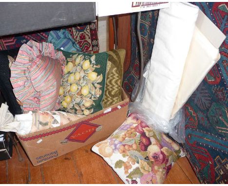 A vintage quilt, several, several woolwork and other cushion and two rolls of plain fabric