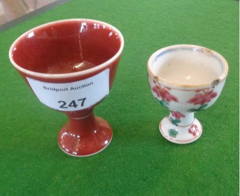 Chinese Sang de Bouef egg cup with character marks and a famille rose egg cup