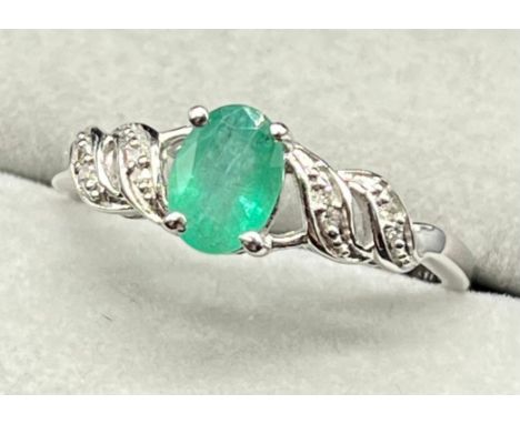 10ct white gold ring set with an oval cut emerald stone with diamond shoulders. [Ring size Q] [2.26Grams] 