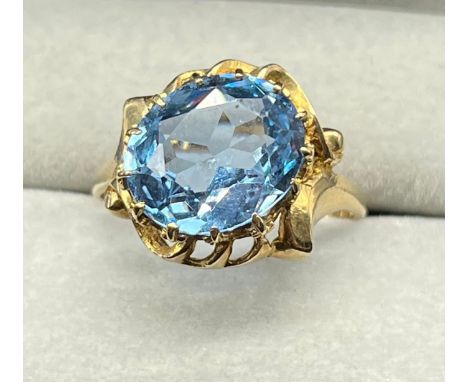 9ct yellow gold ring set with a large oval cut blue topaz stone. [Ring size O] [3.20Grams] 