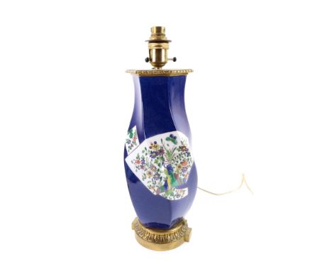 A French porcelain powder-blue ground table lamp with gilt-metal mounts, late 19th/early 20th Century, the wrythen moulded bo