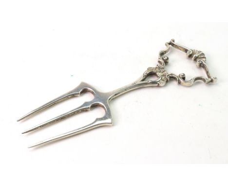An ornate three-prong silver bread fork, Peter Henderson Deere, London 1912, with cast shell and scroll handle in rococo styl