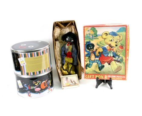 A Gift Box Two jigsaw puzzle of a golliwogg with a Teddy bear, together with a pack of Nell Gwyn 'Golly' playing cards, a gol