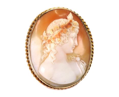 A Victorian gold and shell cameo brooch, the oval portrait cameo carved depicting a classical lady with a garland in her hair