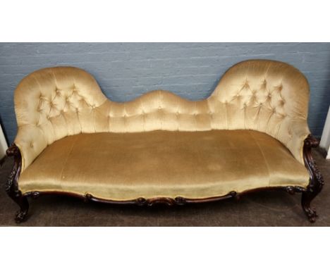 A Victorian carved rosewood frame double spoon back sofa, button down upholstered, on cabriole legs and ball and claw feet, o